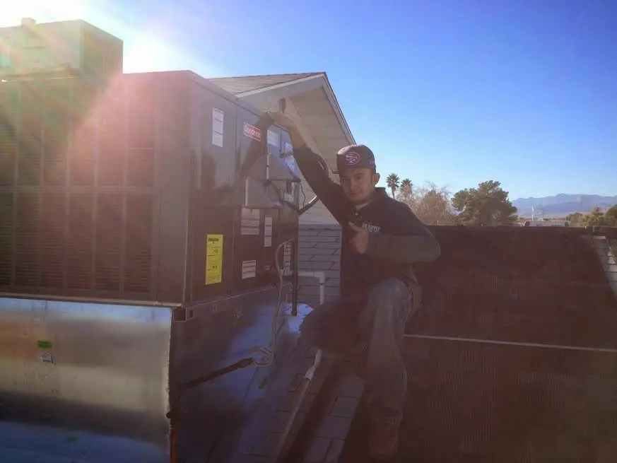 HVAC technician performing Air Duct Cleaning on a rooftop unit in Cumberland